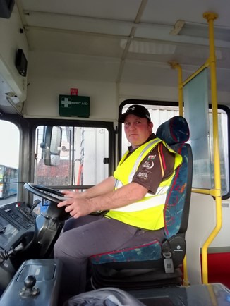 Andrew driving a bus